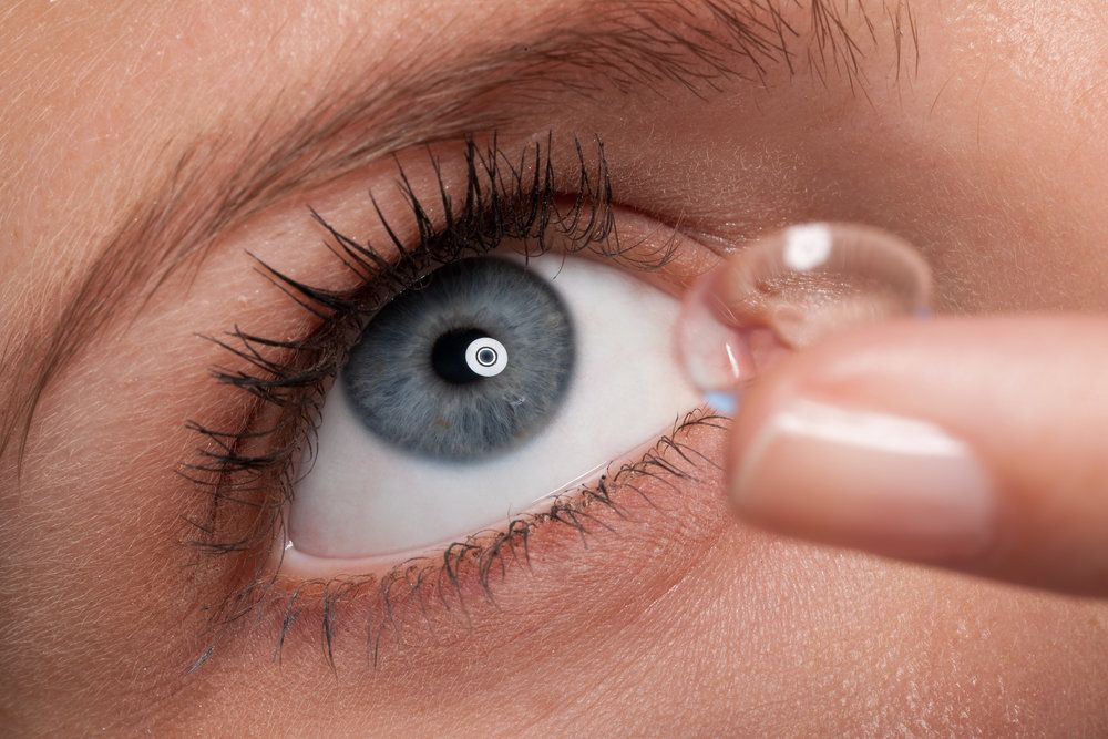 Close-up of a woman putting in a custom contact lens